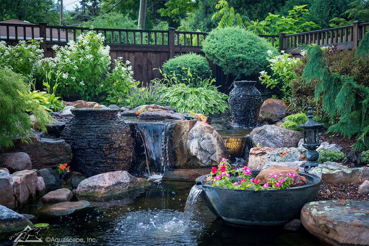 Skilled installer adjusting waterfall stone placement for balanced water flow and appearance