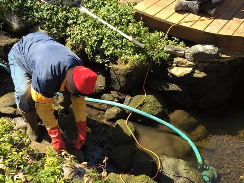 Skilled pond contractor assessing soil and water flow on a Newcastle, OK property