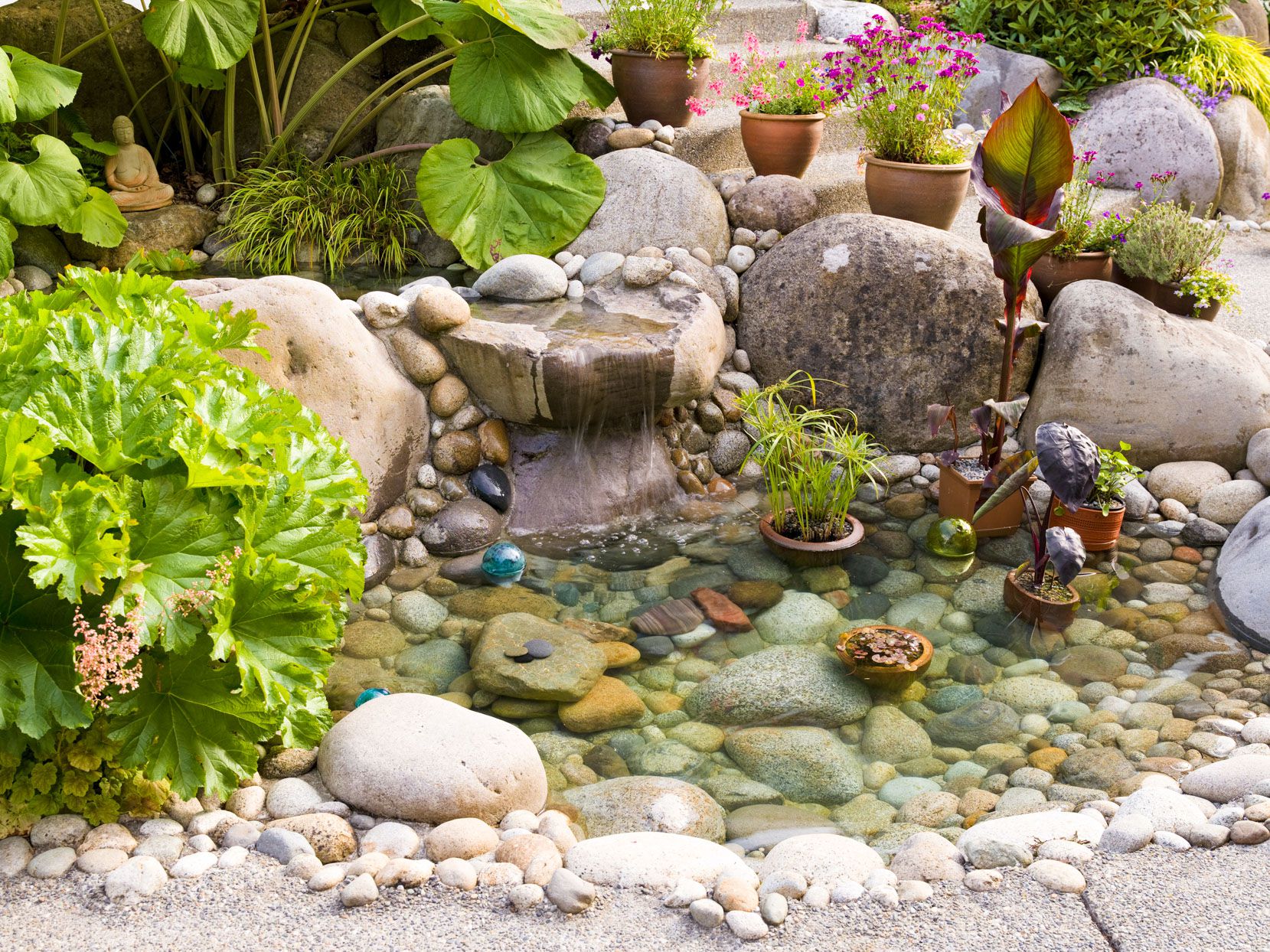 Landscape crew refining Water Features rock placement in a Midwest City, OK backyard setting