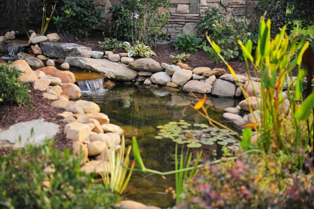 Water Features in Lexington, OK being installed as a crew shapes stone around a new fountain basin