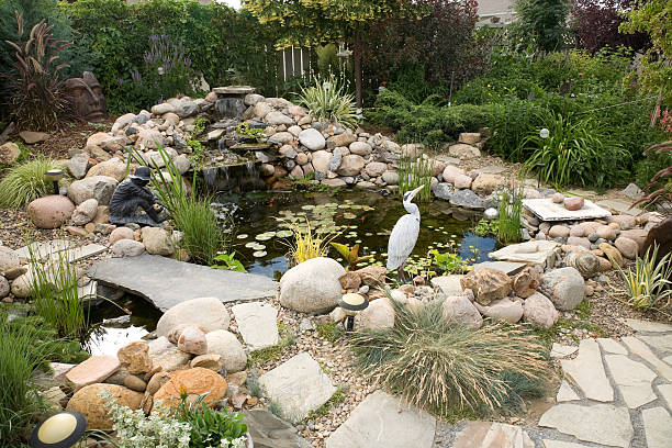 Installer fine-tuning water features beside a landscaped bed in Newcastle, OK for balanced flow